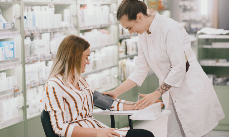 Eine Ärztin misst den Blutdruck einer Patientin.